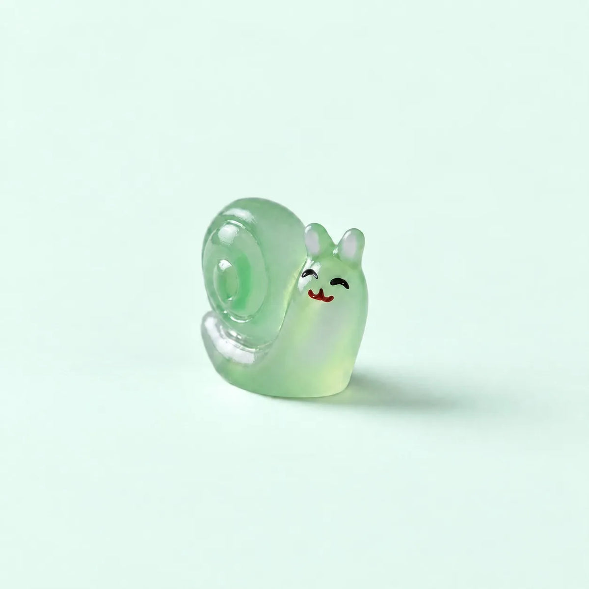 Miniature Glow Snail Assorted (1pc) displayed on a mint green background